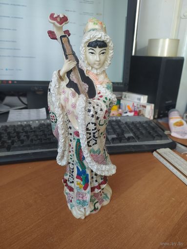 Статуэтка японка в зимнем одеянии со странным инструментом.