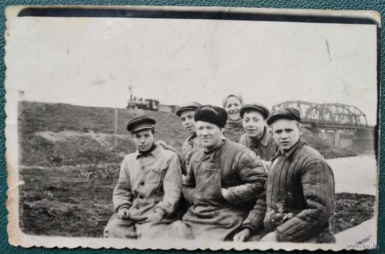 Фото группы строителей (?) на фоне моста и паровоза. 1950-е. 6х9 см.