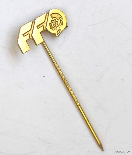 Корпоративный или тематический значок из прошлого. Логотип состоит из стилизованных букв "FF" и знака, напоминающего шестеренку или цветок внутри круга